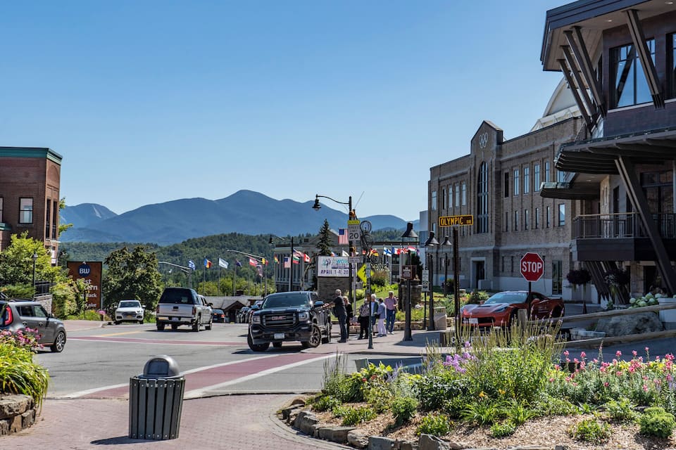 A street with cars, a stop sign, and mountains in the background.