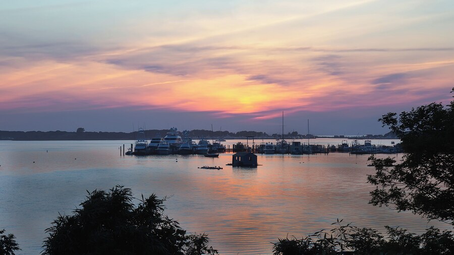 Landscape with lake, boats and sunset sky at Lake Montauk, New York, USA