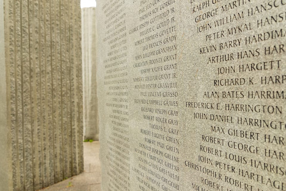 A close-up of a stone wall with engraved names.