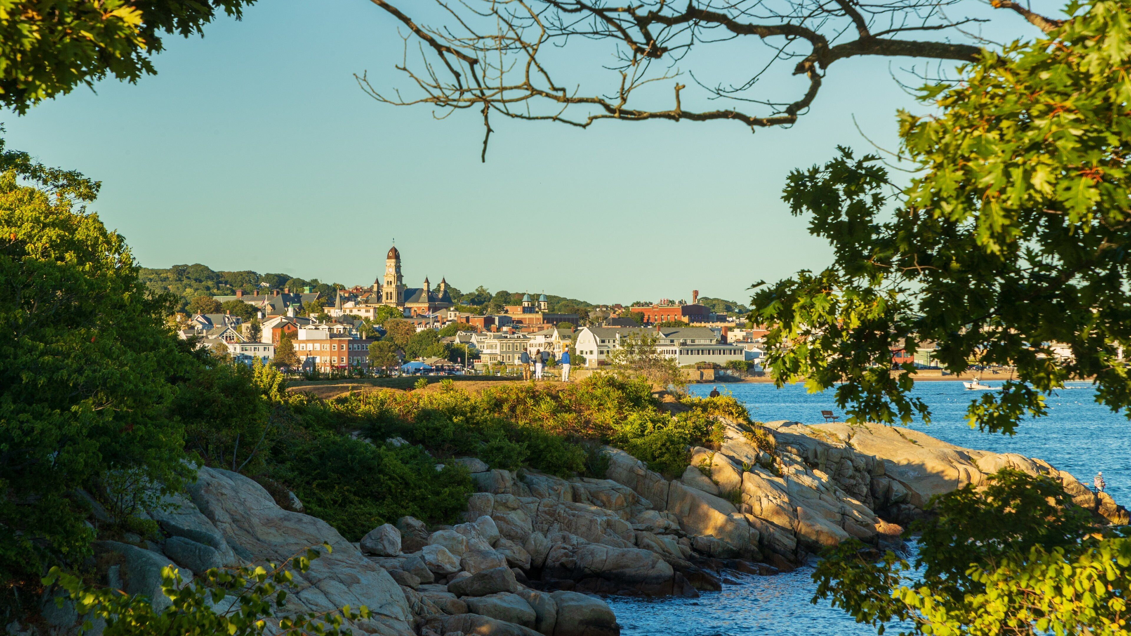 Stage Fort Park which includes a coastal town and rocky coastline