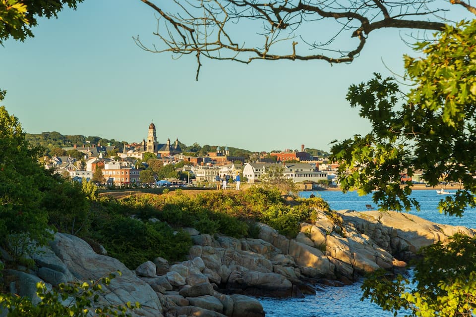 A coastal town with rocky shores, a prominent church, and a clear blue sky.