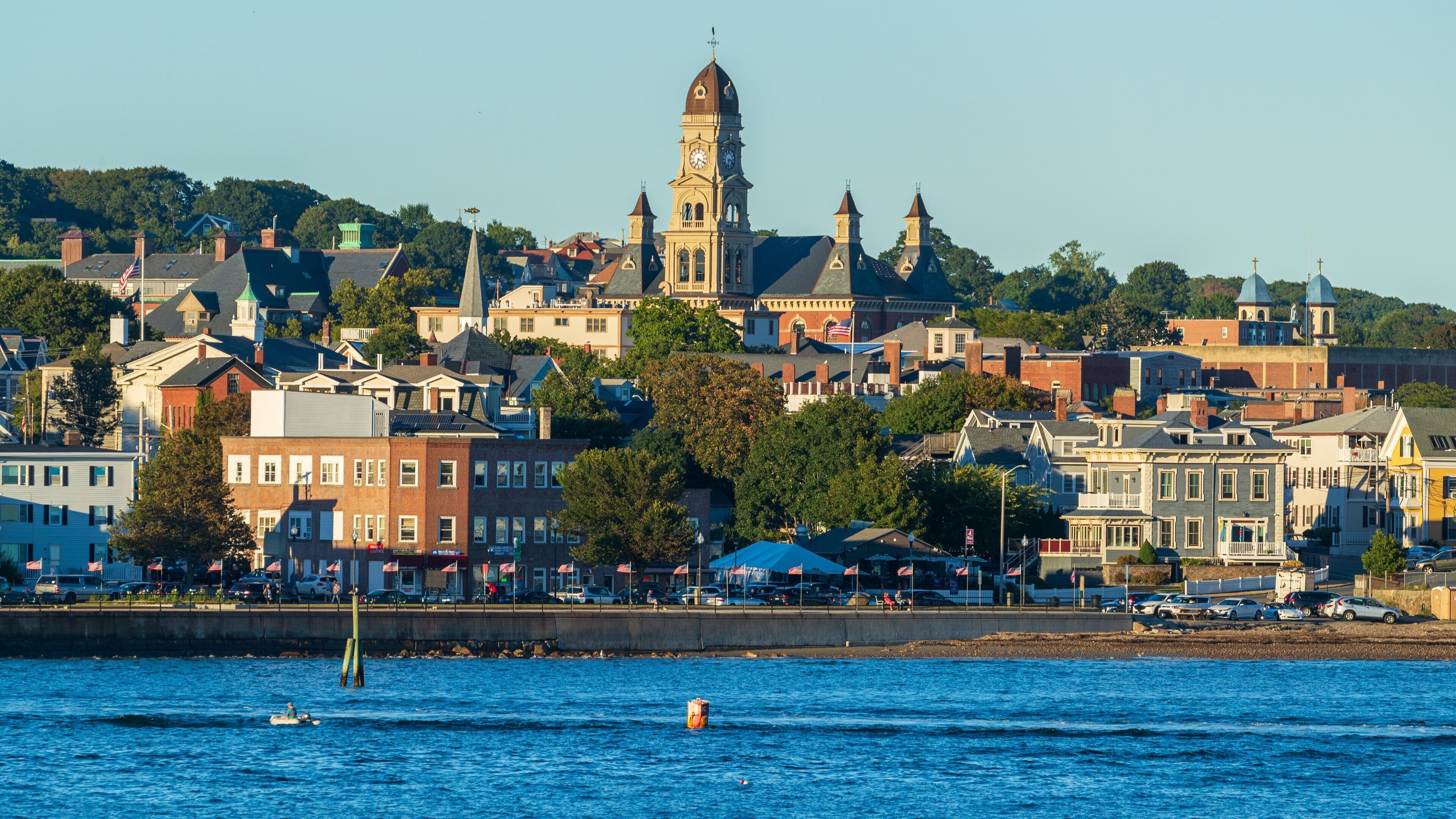 Stage Fort Park which includes a coastal town and a bay or harbor