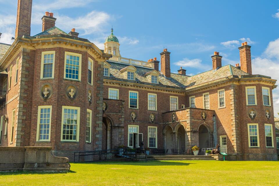 A large brick building with a green dome and multiple chimneys.