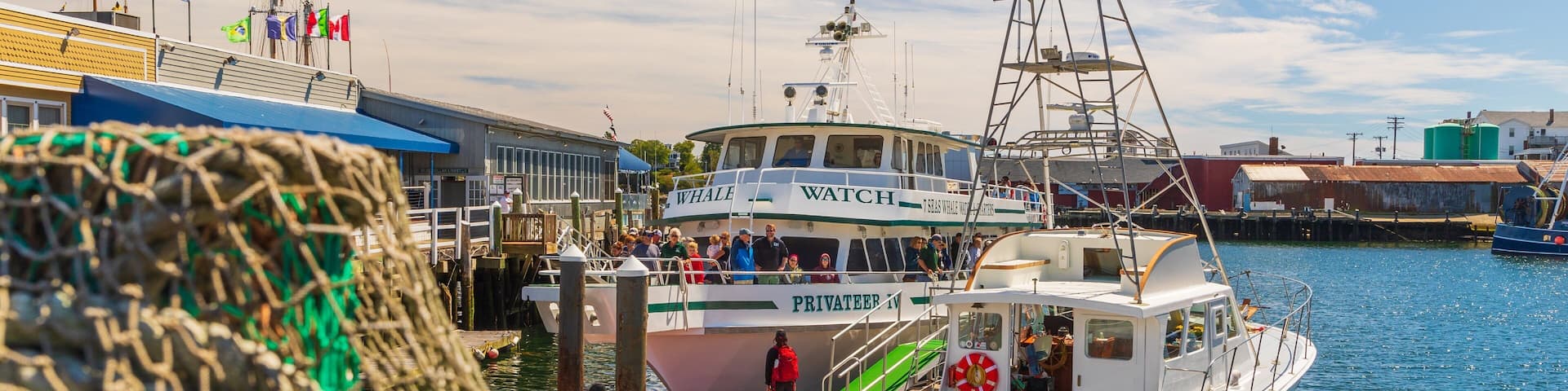 A harbor with boats, including a 'Whale Watch' and a 'Wejack' named boat.