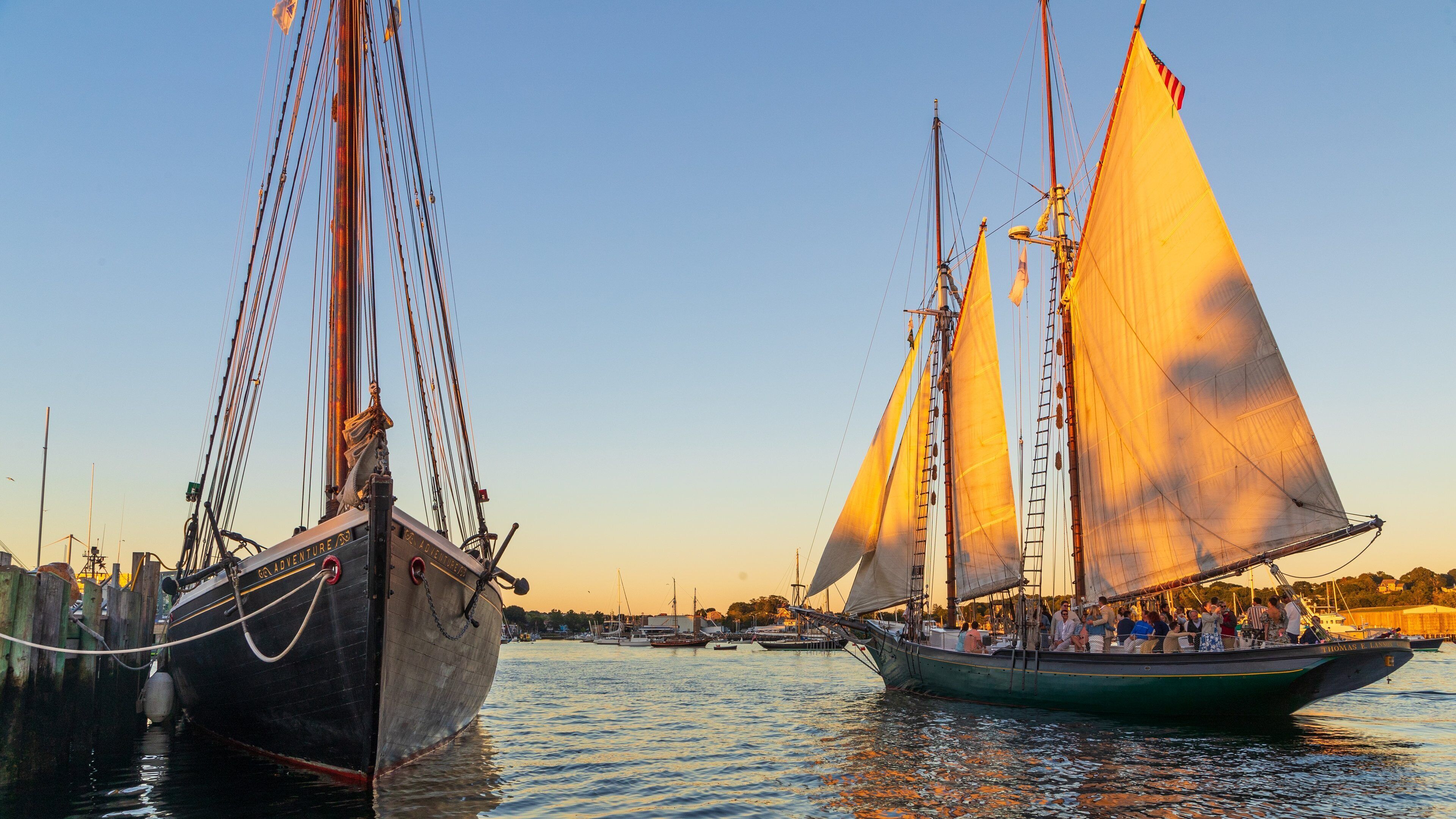 Maritime Gloucester which includes sailing and a sunset as well as a small group of people