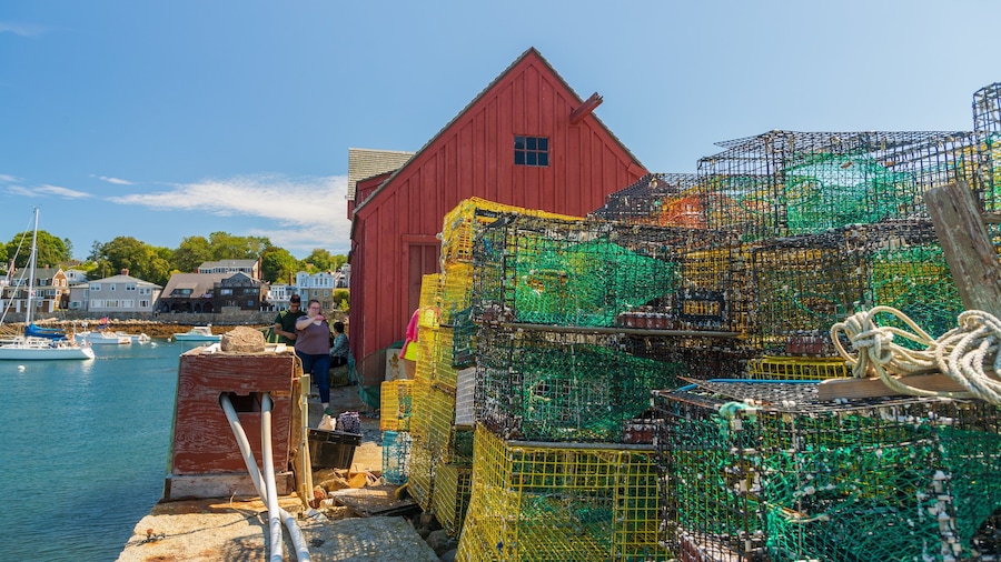 A red building by a harbor with stacked lobster traps.