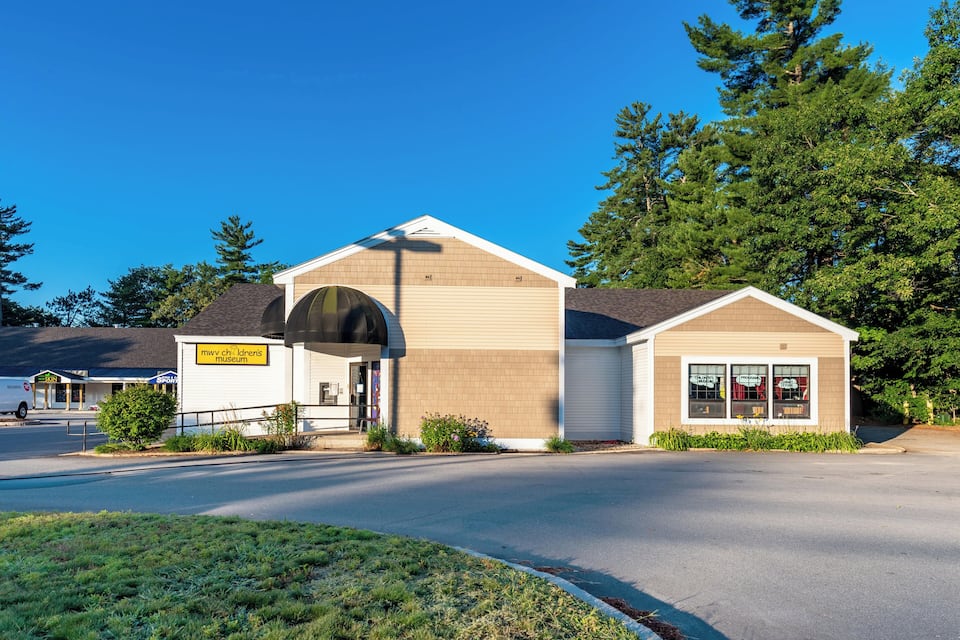 A museum building with a sign reading "mww chldren's museum" and a large arched entrance.