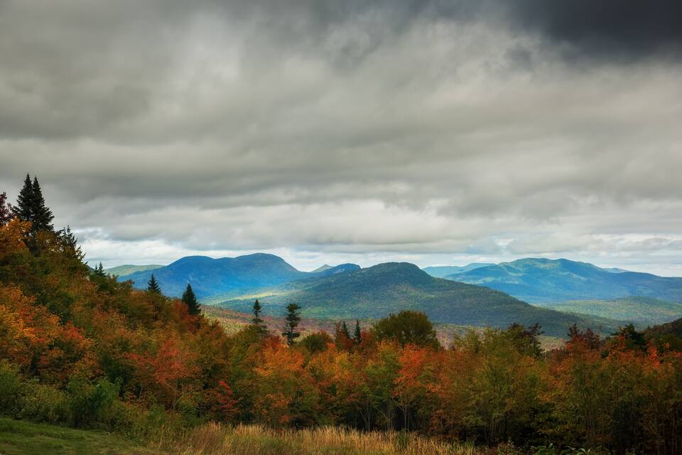A mountainous landscape with autumn foliage and overcast skies.