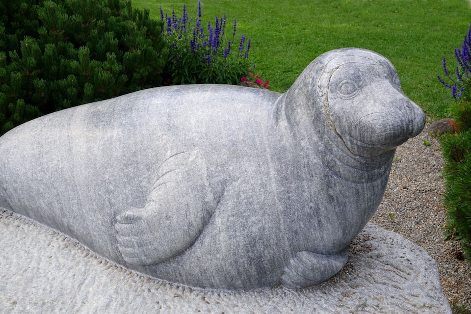 Escultura de pedra d'un focus en un jardí.