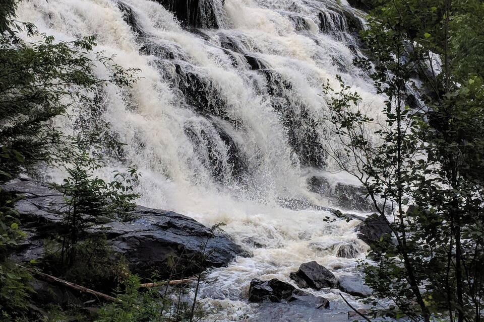 A waterfall cascading over rocks in a forested area.