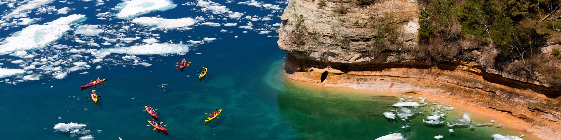 Kayaks at Miners Castle on Lake Superior. Late ice breakup created unusual ice formations at Pictured Rocks National Lakeshore in the Upper Peninsula of Michigan