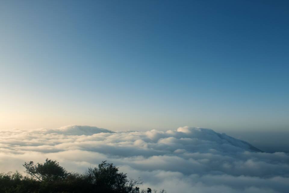 A mountain range with clouds below.