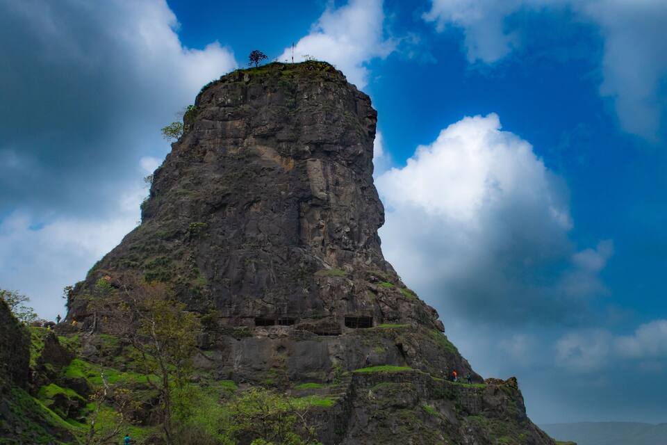 A rugged mountain peak with a person standing at the top.