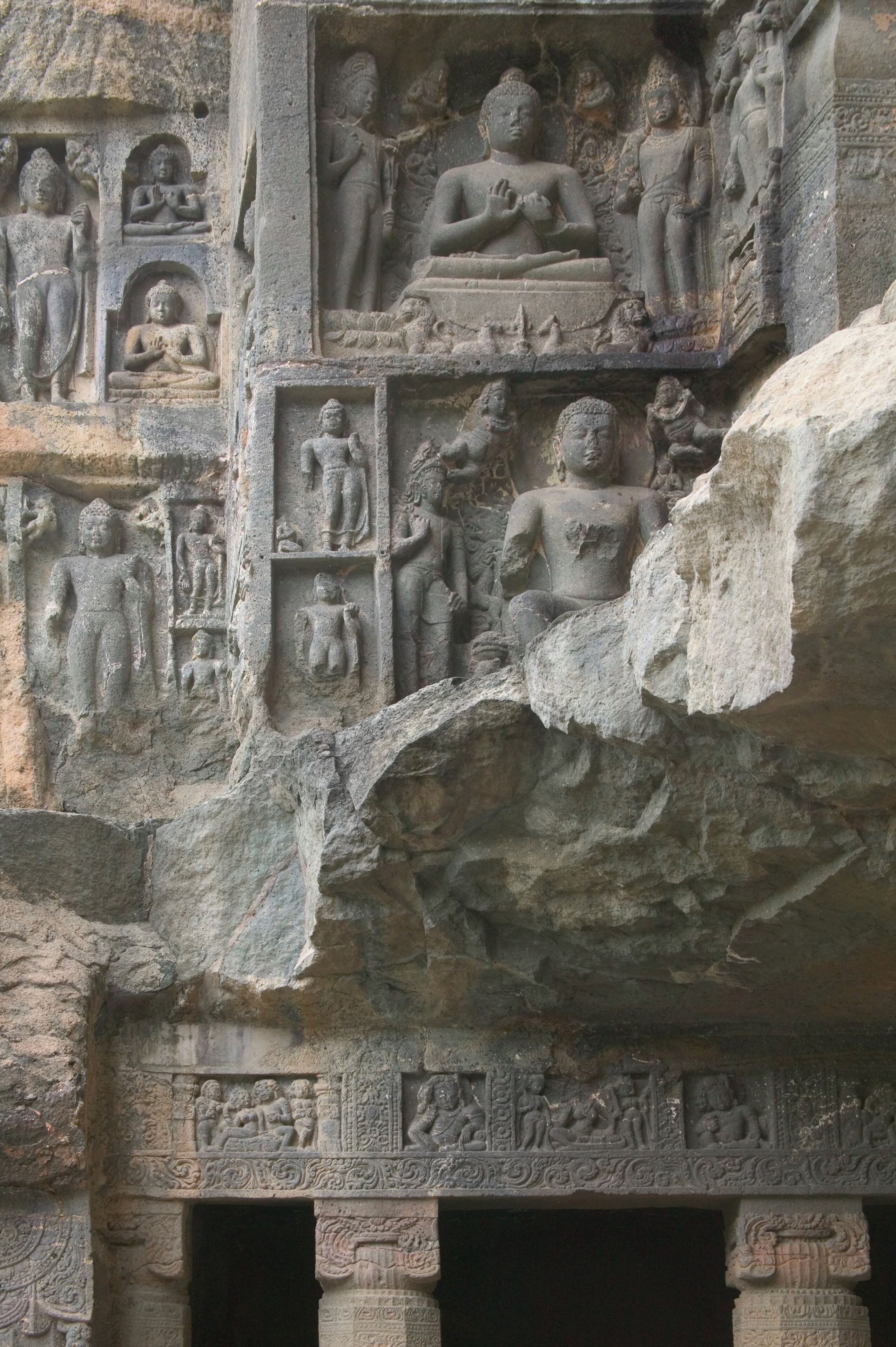 A detailed stone carving of a seated figure surrounded by smaller figures, likely depicting a historical or religious scene.
