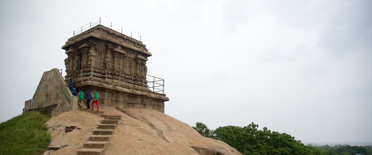 A stone structure with steps leading up to it, surrounded by greenery.