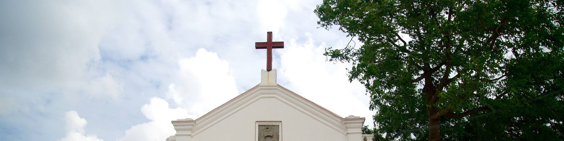A white church with a cross on top and the words "MY LORD AND MY GOD" above the entrance.