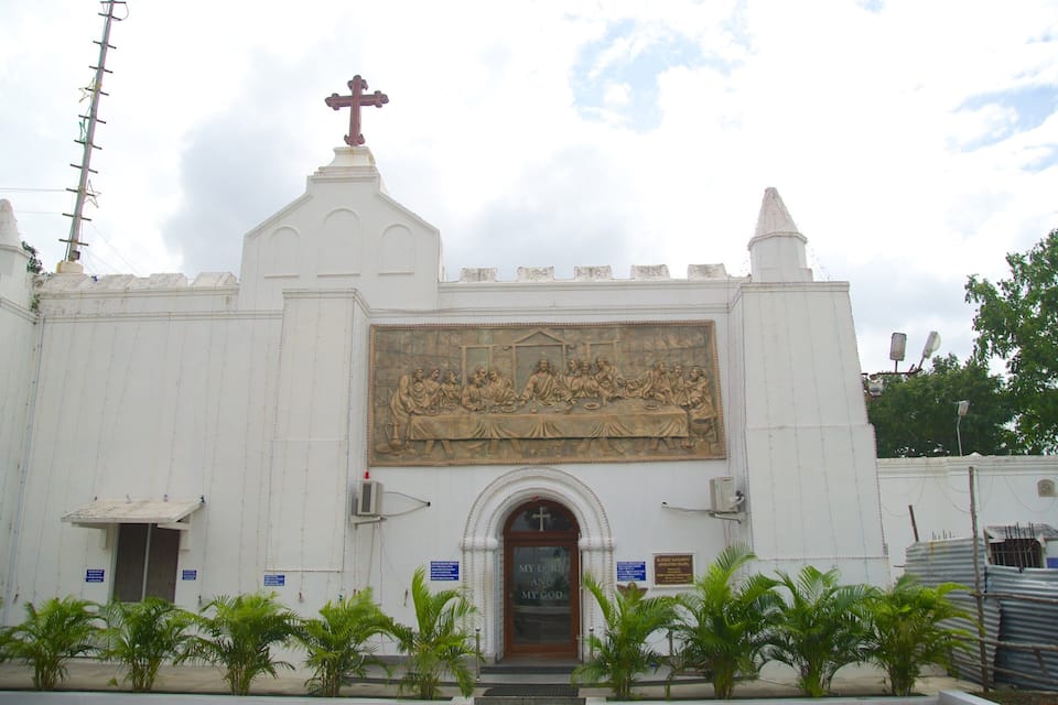 A white church with a large mural depicting a biblical scene.