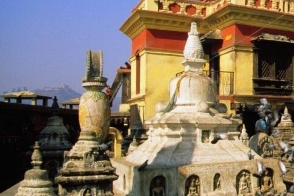 Ett tempelkomplex med en detaljerad och intrikat arkitektur, inklusive en framträdande stupa och mindre helgedomar.