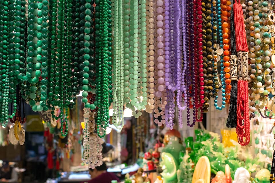 Una variedad de cuentas y joyas coloridas colgadas en un mercado.