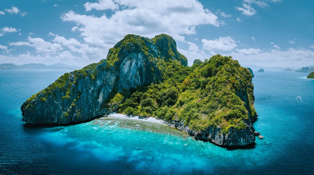 Aerial drone panorama picture of tropical paradise epic Entalula Island. Karst limestone rocky mountains surrounds the blue lagoon with beautiful coral reef