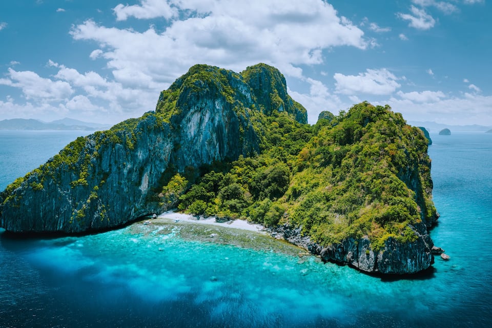 A large, lush green island surrounded by clear blue waters.