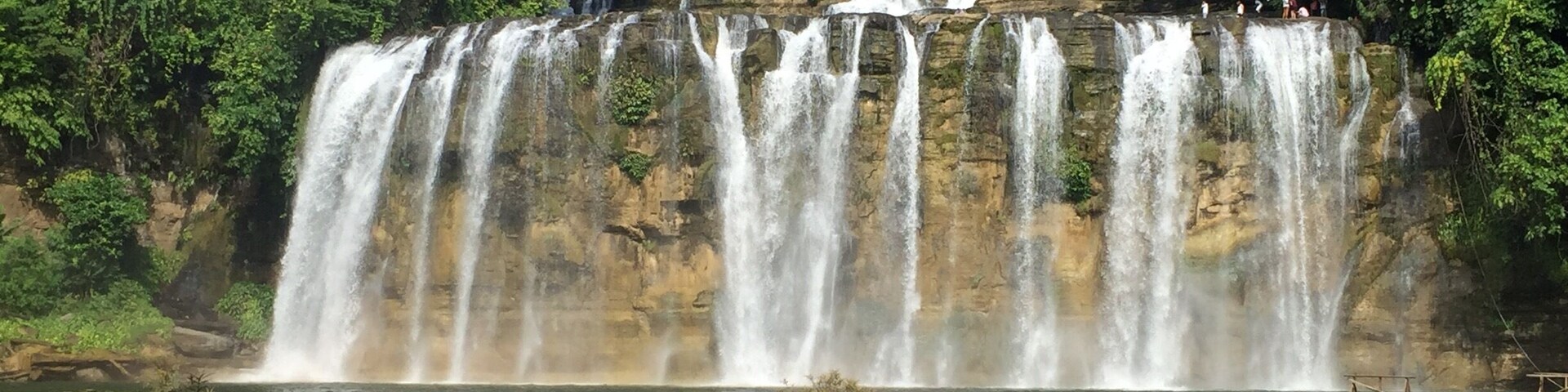 Uma cascata em vários níveis, rodeada por vegetação exuberante.