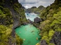 Aerial drone view of a beautiful tropical lagoon filled with kayaks and surrounded by jagged limestone cliffs (Small Lagoon, Miniloc Island, El Nido)