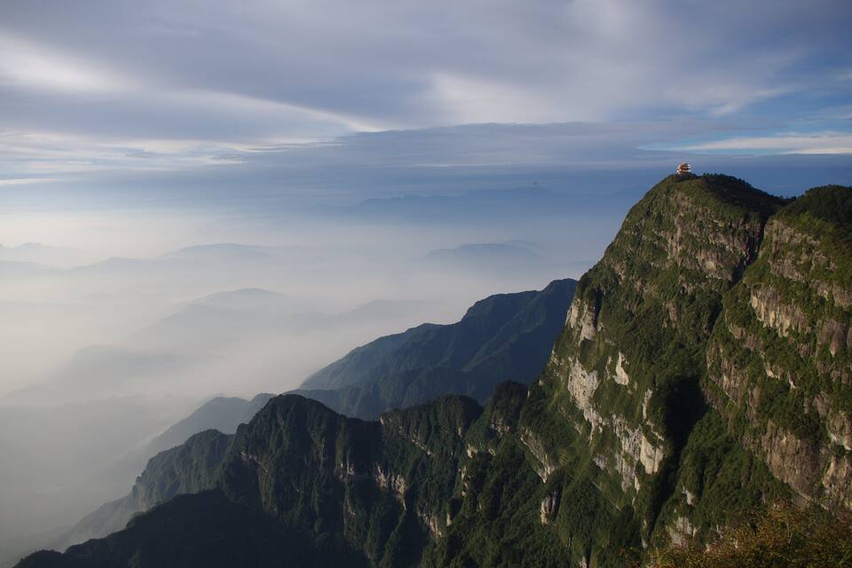A mountain range with a temple on top.