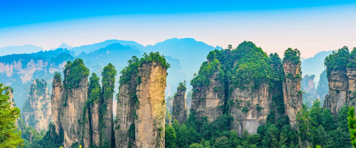 Towering limestone cliffs with dense forest vegetation.