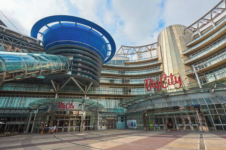 A modern architectural complex with a prominent curved blue structure and the 'Big City' sign.