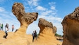 A group of tourists at a rock formation with unique shapes.