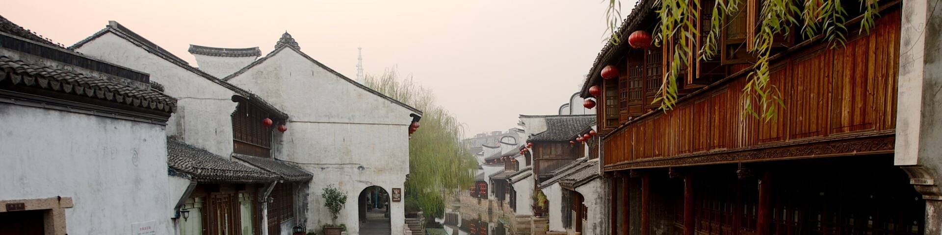 A narrow waterway flanked by traditional buildings with wooden balconies and tiled roofs.