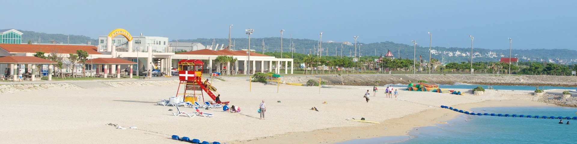 Okinawa que inclui uma praia de areia, natação e uma cidade litorânea