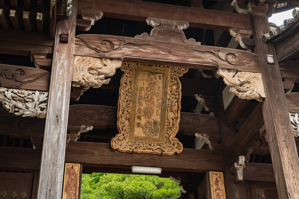 A traditional wooden structure with ornate carvings and a framed picture.