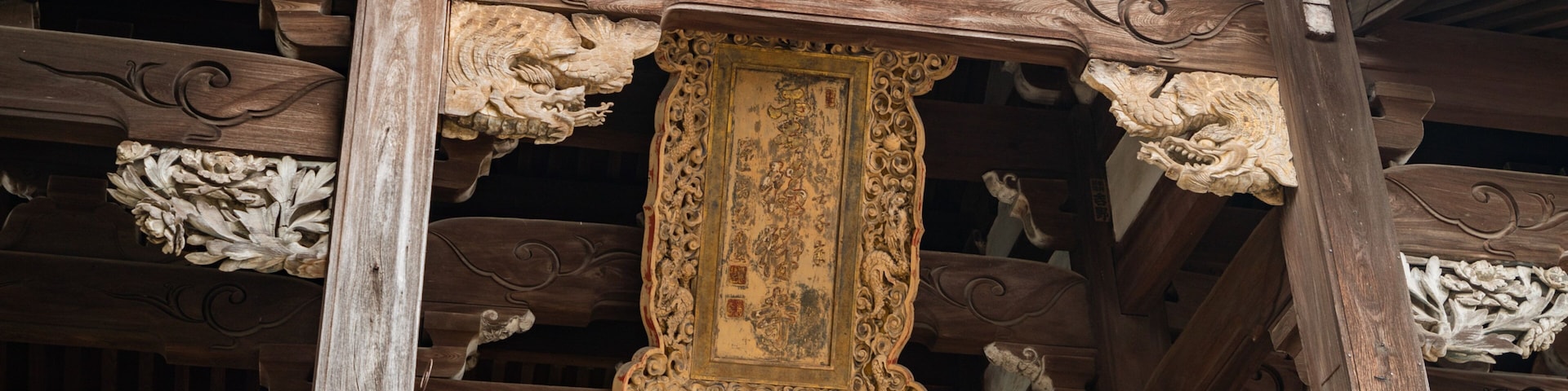 Uma estrutura de madeira tradicional com esculturas elaboradas e um quadro emoldurado.