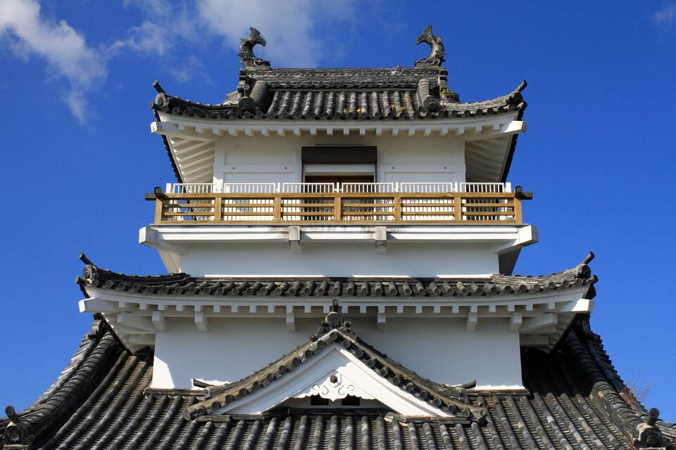 A traditional multi-tiered pagoda with ornate roof tiles and a balcony.