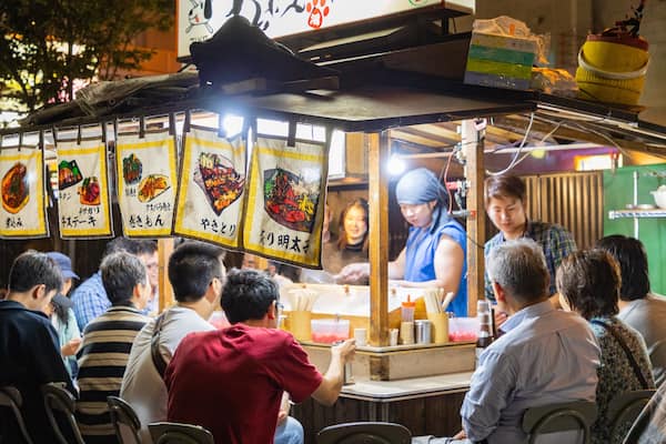 Un stand de restauration de rue où divers plats sont exposés sur le comptoir.