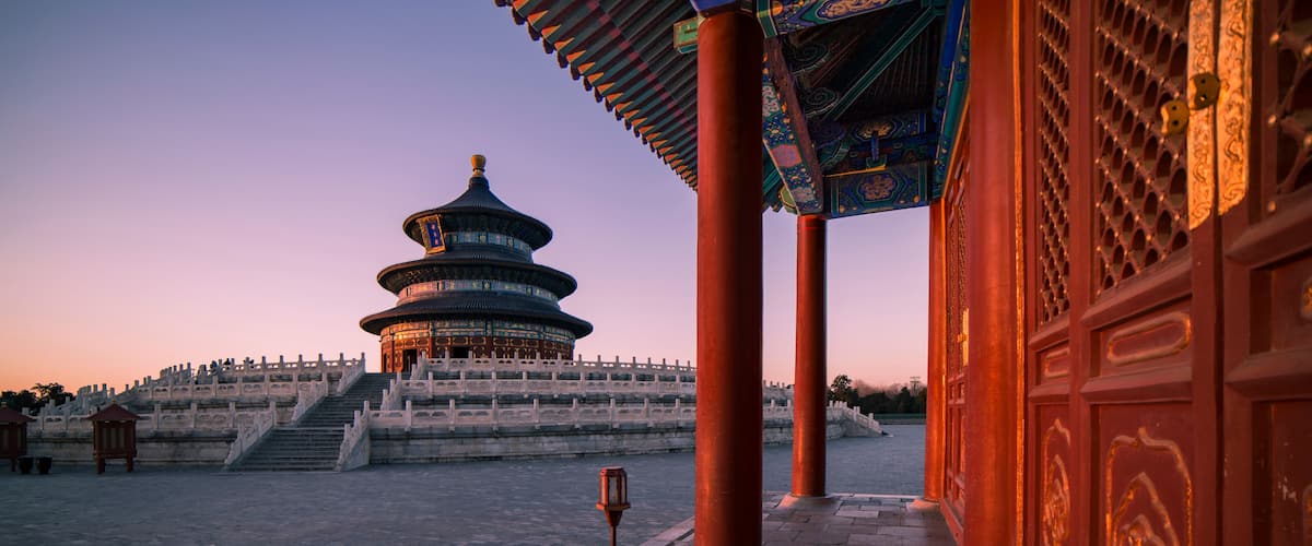 A traditional Chinese pagoda with a circular base and multiple tiers, surrounded by a stone staircase leading up to it.