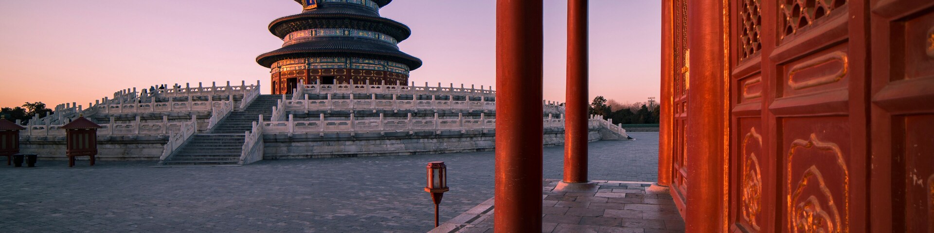 A traditional Chinese pagoda with a circular base and multiple tiers, surrounded by a stone staircase leading up to it.
