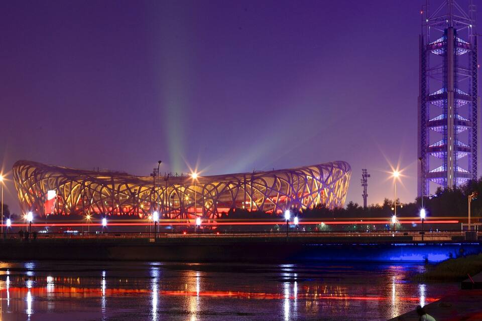 A stadium with a distinctive roof structure and a tall tower.