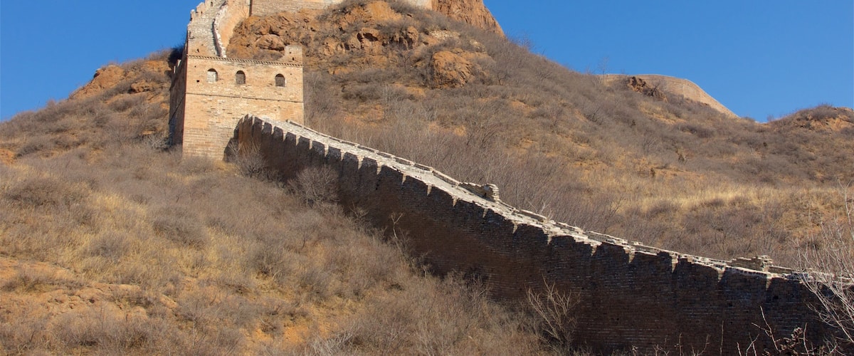 The Great Wall of China with a watchtower and a large fortification on a hill.