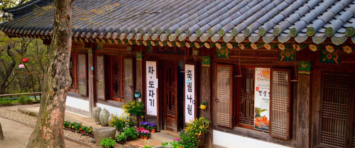 A traditional Korean building with a tiled roof, wooden doors, and colorful decorations.