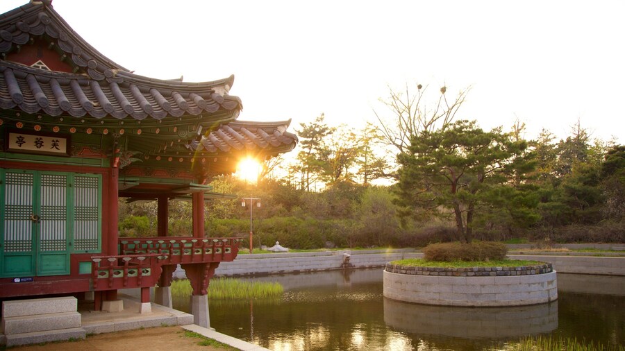 Parque tradicional Wolmi que incluye una puesta de sol, un estanque y elementos del patrimonio