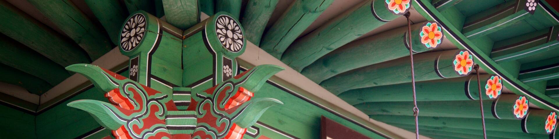 A traditional building with ornate green and red decorations, including floral patterns and a sign with Chinese characters.