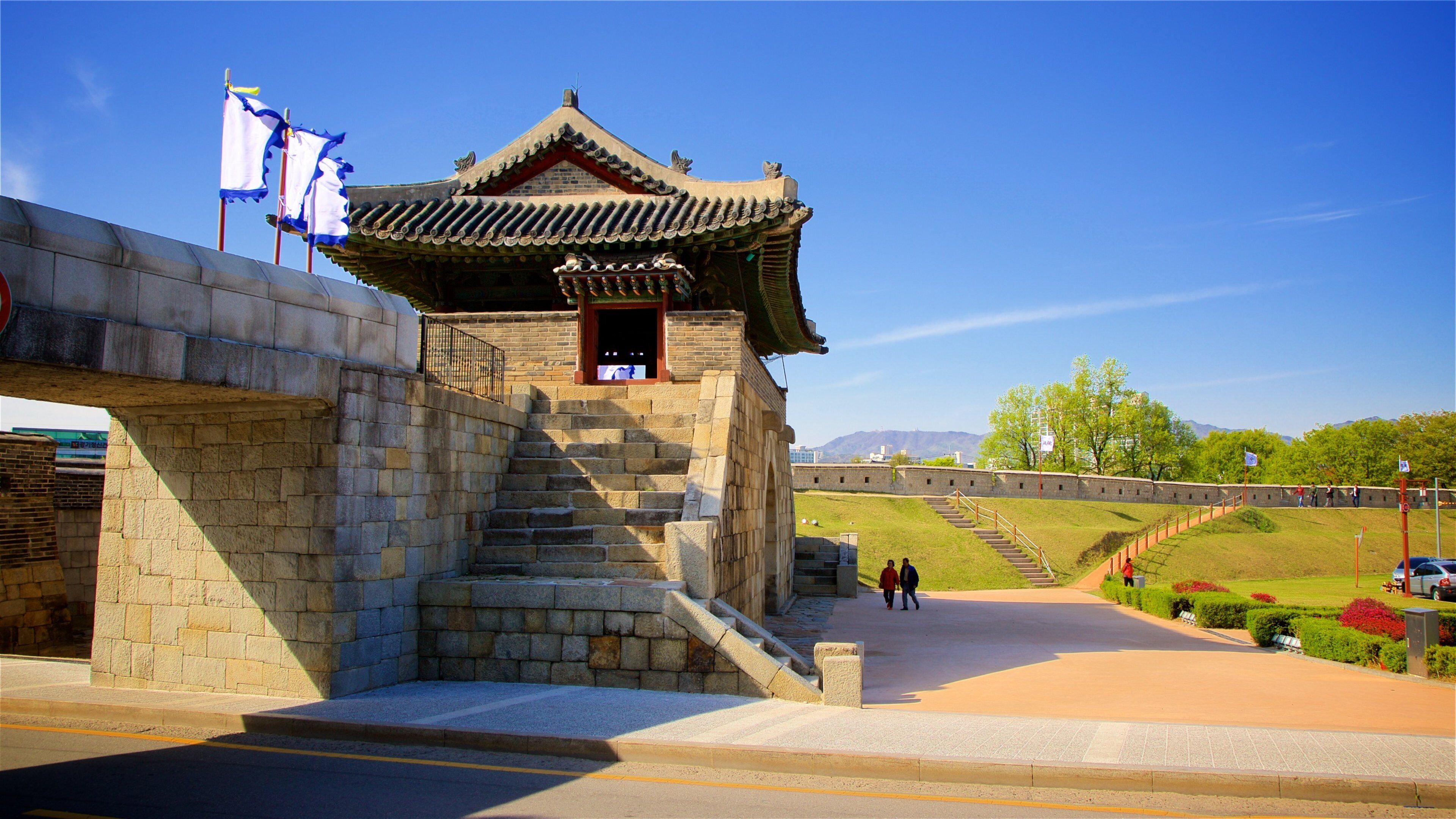 Hwaseomun Gate featuring a bridge, heritage elements and a park