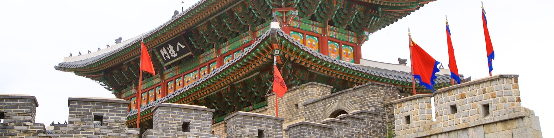 Un edificio tradicional coreano con arquitectura ornamentada y muros de piedra.