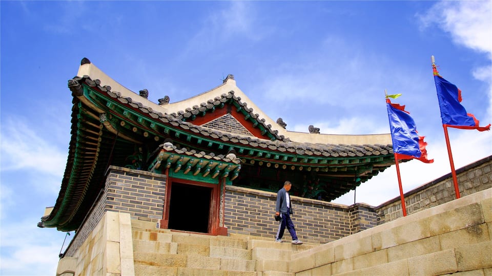 A traditional Korean building with a curved roof and a flagpole with a blue flag.