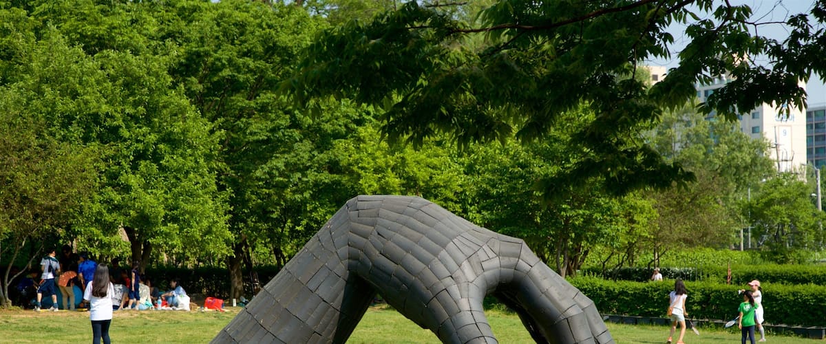 Yongsan Park which includes outdoor art and a garden as well as a small group of people