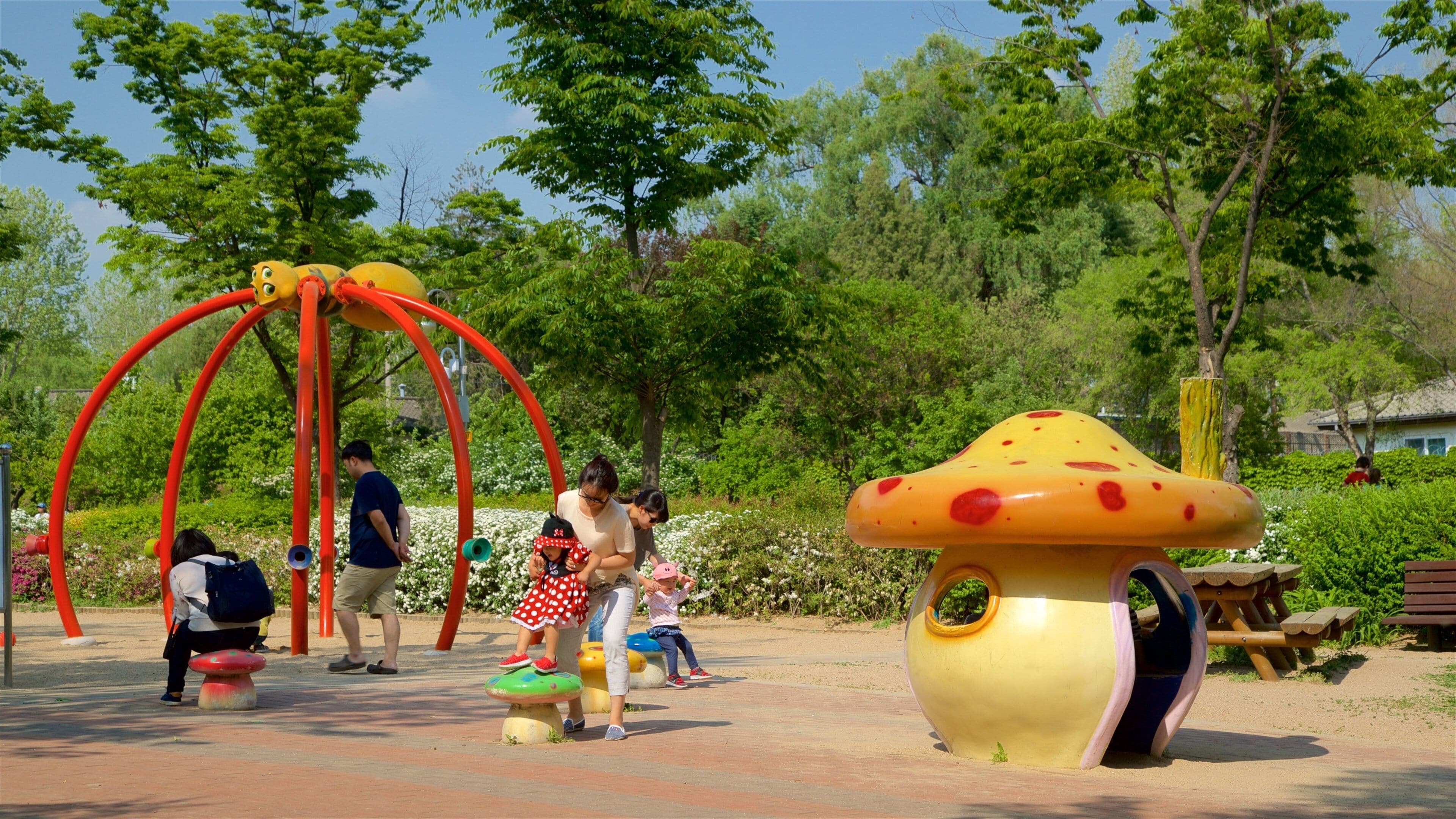 Yongsan Park featuring a garden and a playground as well as a family