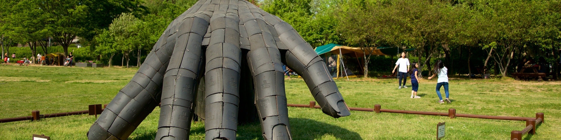 Yongsan Park showing outdoor art and a garden as well as a family